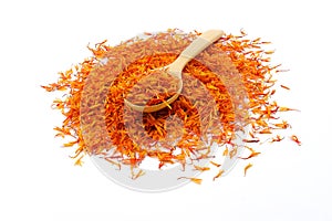 A pile of New Dried Safflower petals herb Tea on a wooden spoon.  on a white background