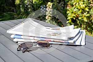 Pile of newspapers and sunglasses