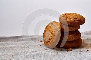 Pile of oat cookies on homespun napkin, close-up, selective focus.