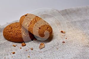 Pile of oat cookies on homespun napkin, close-up, selective focus.