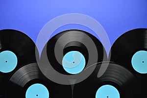 Pile of old black vinyl records on blue