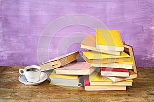 Pile of old books and a cup of coffee. Reading, learning, education, literature concept, panorama, copy space