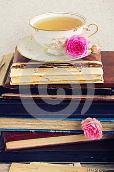 Pile of old books and mail with cup of tea