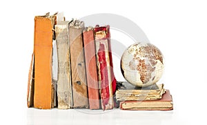 Pile of old books with old globe isolated