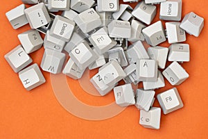 Pile of old computer keyboard keys on the orange background
