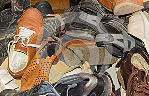 Pile of old different worn footwear