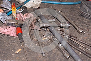 Pile of old and dirty tools in the car mechanic workshop. Screwdrivers and wrench on the floor