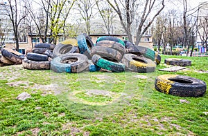 Pile of old multicolored car tires dug in playgrounds. Multicolo