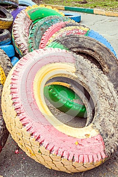 Pile of old multicolored car tires dug in playgrounds. Multicolor used tires. various sizes colored tires