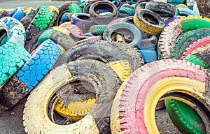 Pile of old multicolored car tires dug in playgrounds. Multicolor used tires. various sizes colored tires