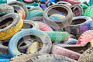 Pile of old multicolored car tires dug in playgrounds. Multicolor used tires. various sizes colored tires