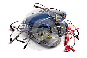 A pile of old reading glasses and glass cases