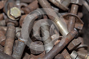 Pile of old rusty screw heads, bolts, metal nuts. Bolt used overlapping full. Bolts and screws used in constructions