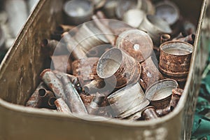 Pile of old rusty shell casings from assault rifles and mounted grenade launchers in metal box