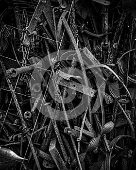 Pile of old, rusty tools including in grayscale