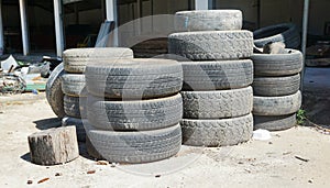 Pile of old tires neatly arranged. Old used tires stacked with high piles, Worn out bald old car tire