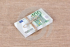 Pile of one hundred euro banknotes tied with rope