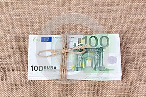 Pile of one hundred euro banknotes tied with rope