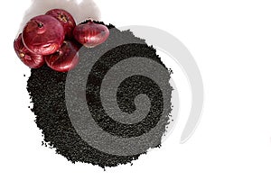 A pile of onion seeds and a bulb on a white background.