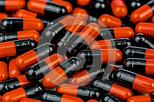 Pile of orange-black capsule pills. Antibiotics resistance. Drug use with reasonable. Global healthcare concept. Antibiotics drug