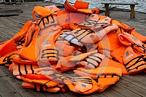 Pile of orange life jackets on a floating dock in ha long bay