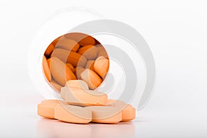 Pile of orange pills on a light background