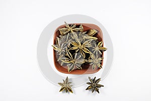 Pile of organic fresh whole star anise in a bowl isolated on white background. close up.top view