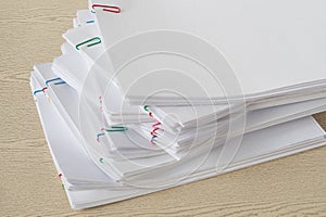 Pile of overload document and reports with colorful paper clip