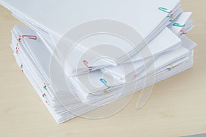 Pile of overload paperwork and reports with colorful paper clip