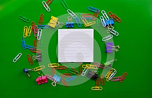 Pile of paper clips isolated on green background, documents, office supplies concept, dirty office desk. Empty place for writing