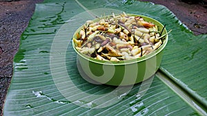 Pile of partially rotten green chilies in a green container