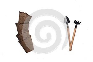 A pile of peat pots and gardening tools isolated on white background flat lay