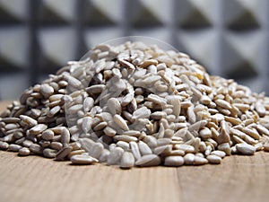 A pile of peeled sunflower seeds on a wooden surface, macro shot