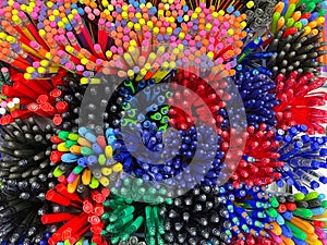 Pile of pens and pencils of different colours. Background texture. Selective focus