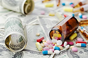 Pile of pharmaceutical drug and medicine pills on dollar money, cost of healthcare and medical insurance
