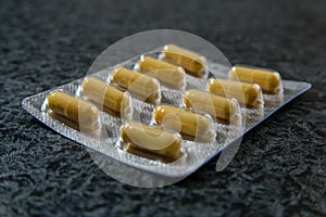 Pile of pills in blister pack with capsules.