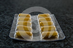 Pile of pills in blister pack with capsules.