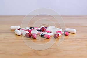 The pile of pills capsules on wood table
