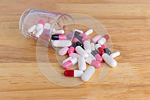The pile of pills capsules on wood table