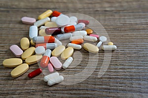pile of pills of many colors on the table. self-medication excessive consumption resistance