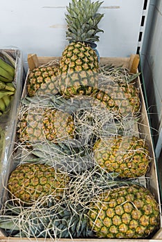 A pile of pineapples placed inside a wooden box photo