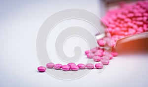 Pile of pink round sugar coated tablets pills on drug tray with copy space.