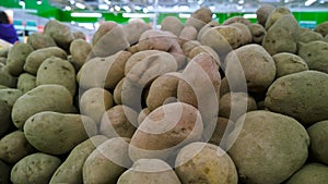 Pile of potatoes on supermarket shelves for sale. Vegetables background. Fresh food. Healthy eating and lifestyle. Local farmers