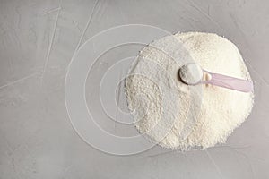 Pile of protein powder, scoop and space for text on grey background