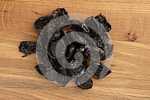 Pile of prunes, dry plums isolated on wood background