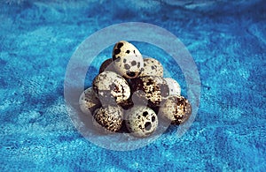 Pile of quail eggs against blue background