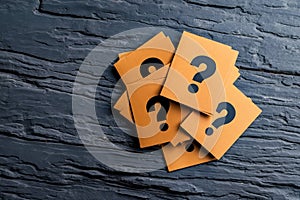 A pile of question marks on a black surface