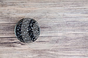 Pile of raw Black Beans in a bowl. black beans on wood background. Dry black beans in dark wooden bowl.