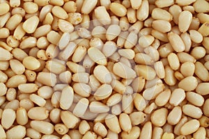 A pile of raw shelled pine nuts arranged randomly. View from above. Closeup