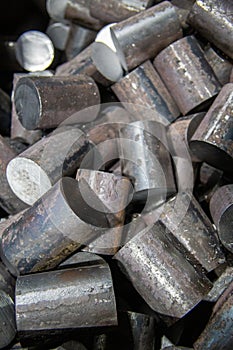 A pile of raw steel short rods cutted by saw - workpieces prepaired for forging, close-up with selective focus photo